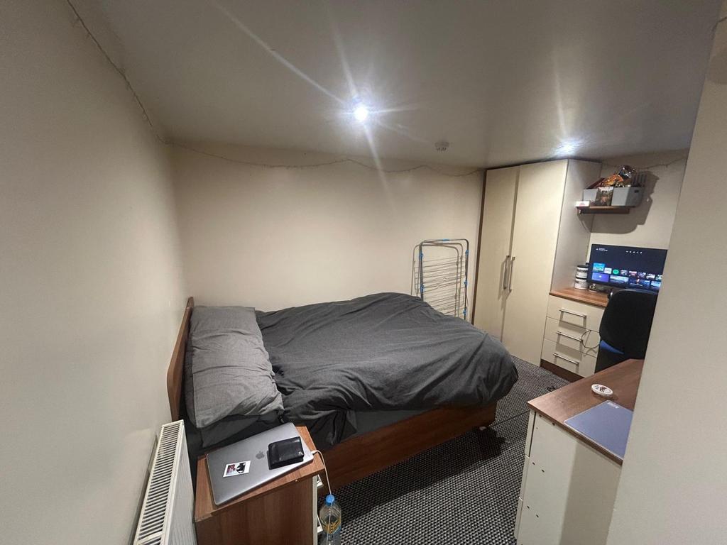 A cozy bedroom featuring a double bed with dark...