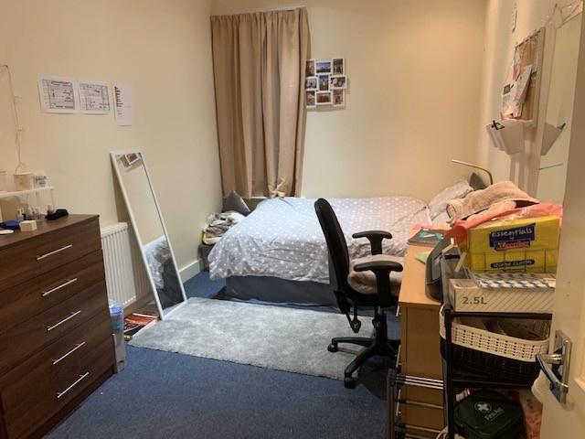 A cozy double bedroom featuring a large bed and...