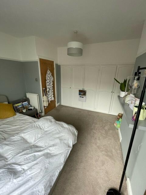 A spacious double bedroom with a large bed, amp...