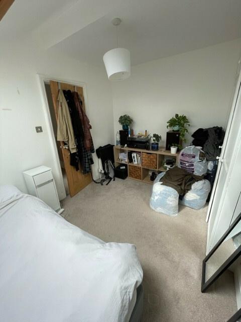 A cozy bedroom featuring a neatly made bed, a s...