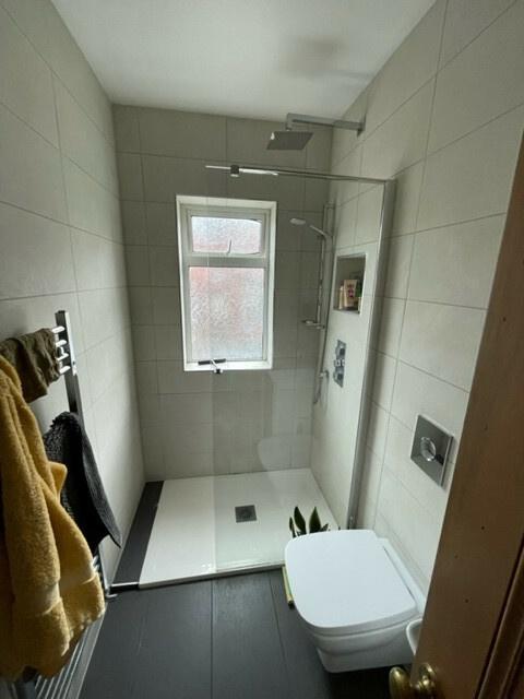 A contemporary, clean bathroom with a walk-in s...