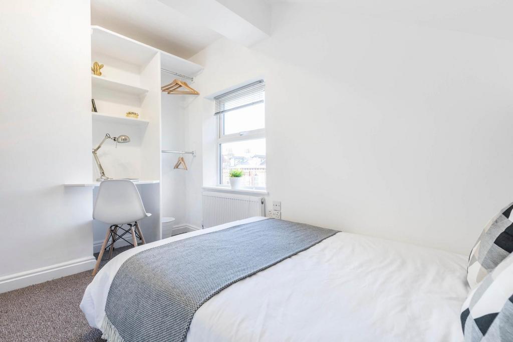 A neat and bright bedroom featuring a comfortab...