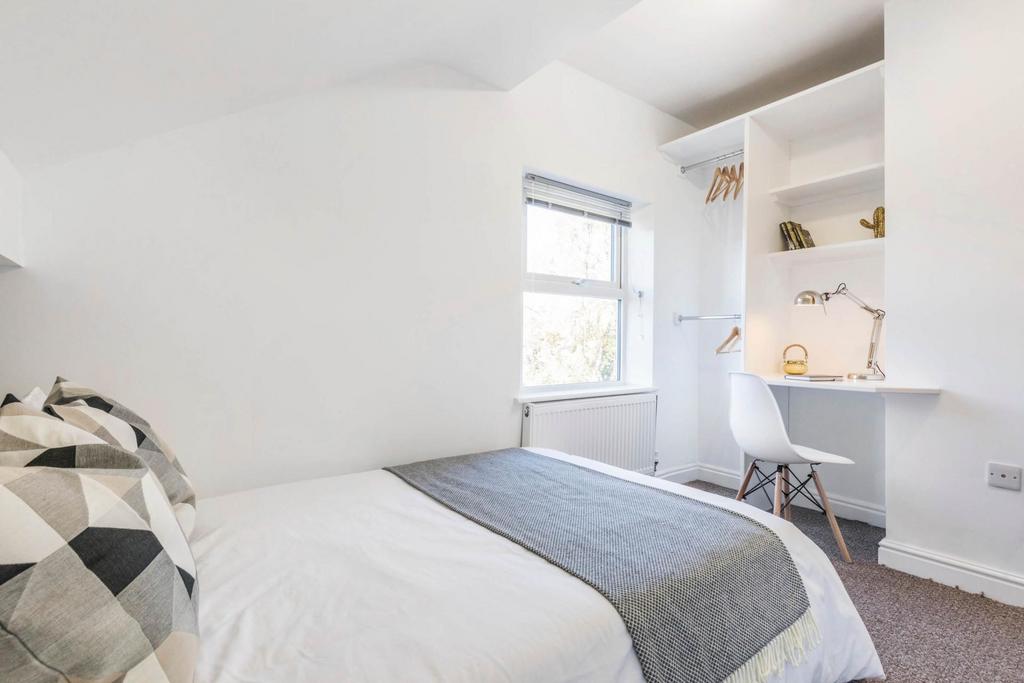 A bright and tidy bedroom featuring a comfortab...