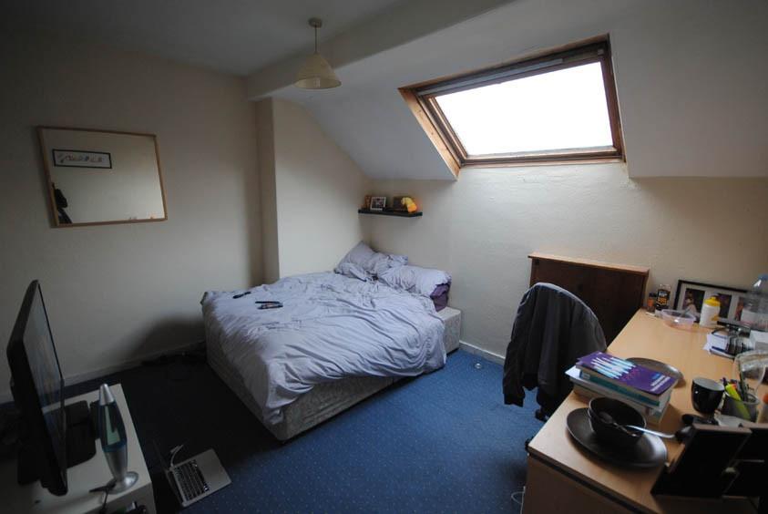 A cozy bedroom featuring a comfortable bed posi...