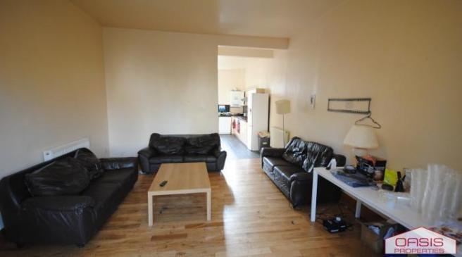 A spacious, well-lit living room featuring cont...