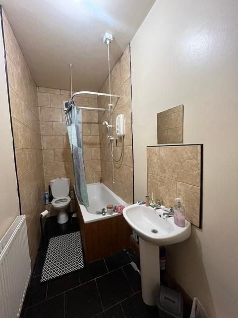 A bright and tidy bathroom featuring a bathtub ...