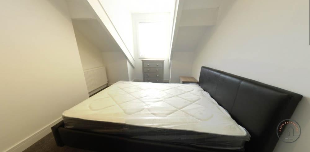 A spacious and well-lit master bedroom featurin...