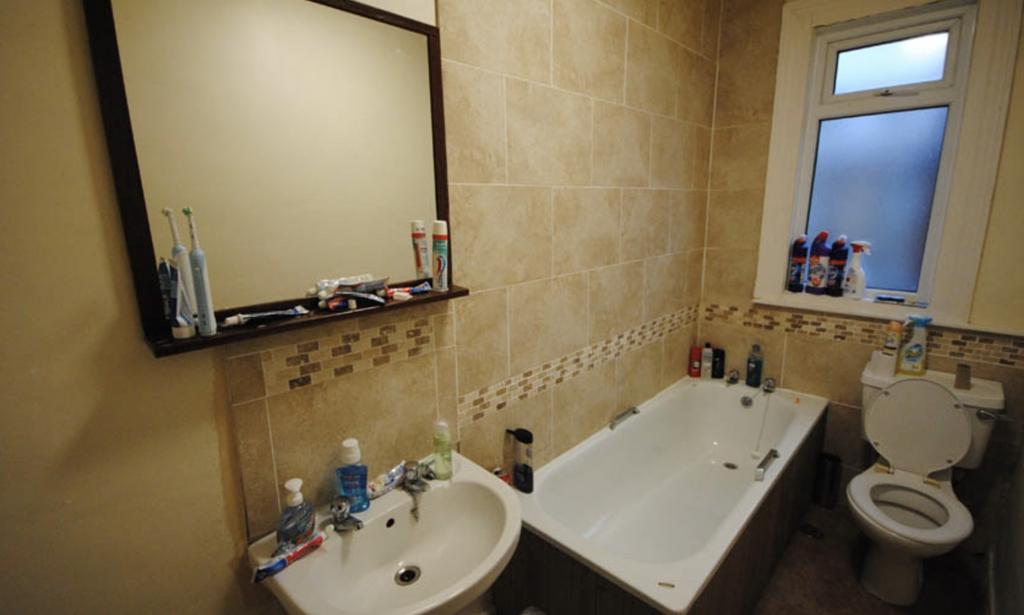 A well-maintained bathroom featuring a bathtub,...