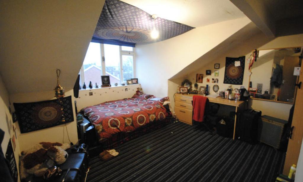 A cozy bedroom featuring a double bed with a co...