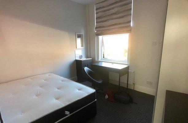 A comfortable single bedroom featuring a large ...