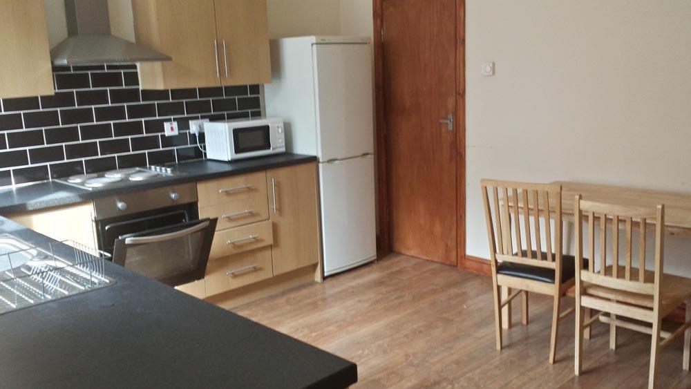 A modern kitchen area featuring wooden cabinets...