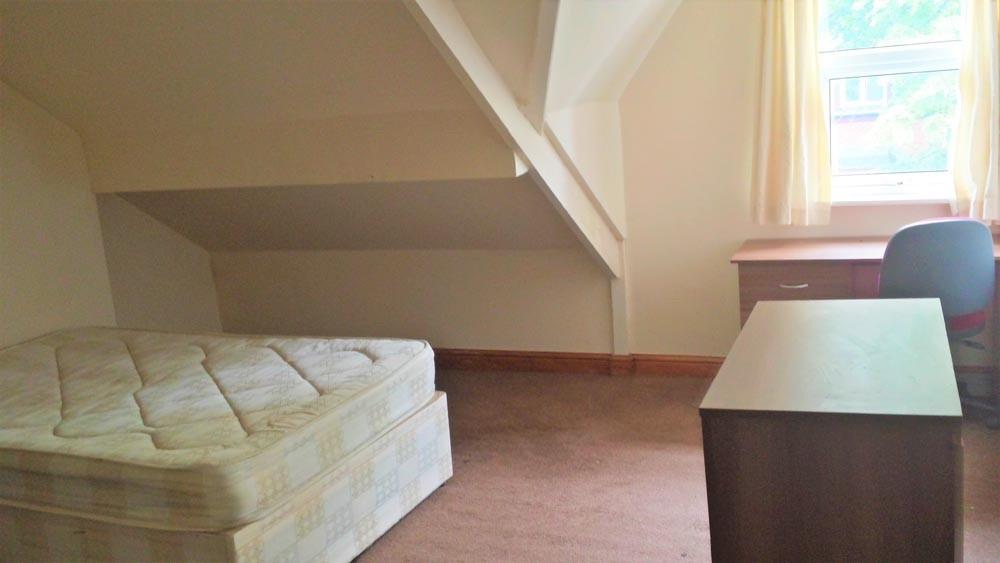 A cozy bedroom with a single bed and a window t...