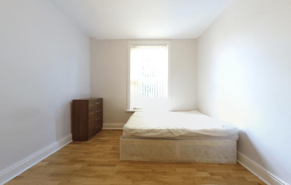 A bright and minimalist bedroom featuring a lar...