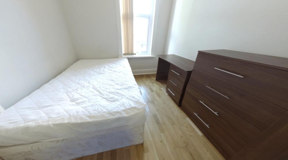 A bright and clean bedroom with a large window ...
