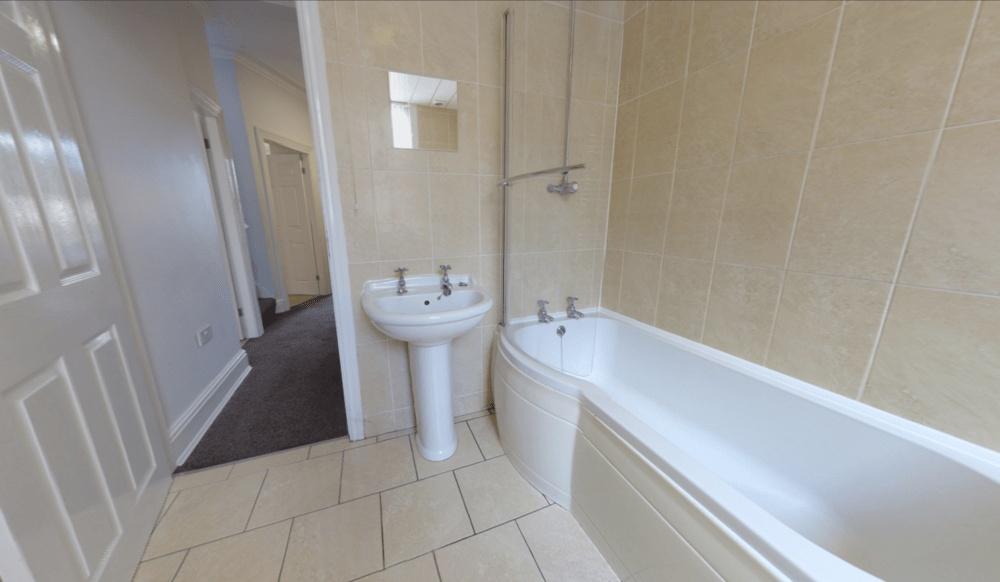 Bright and clean bathroom with a bathtub, sink,...