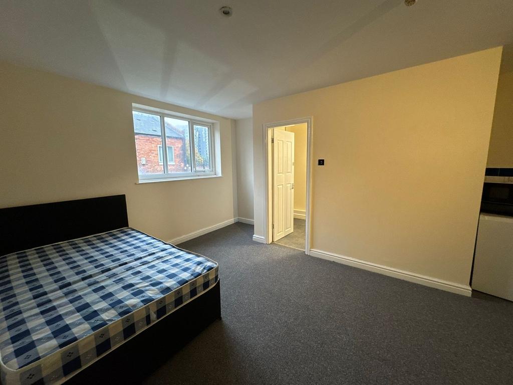 A tidy bedroom featuring a window allowing natu...