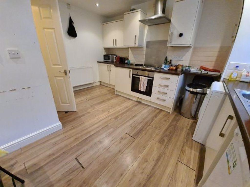 A well-lit, modern kitchen with white cabinets ...