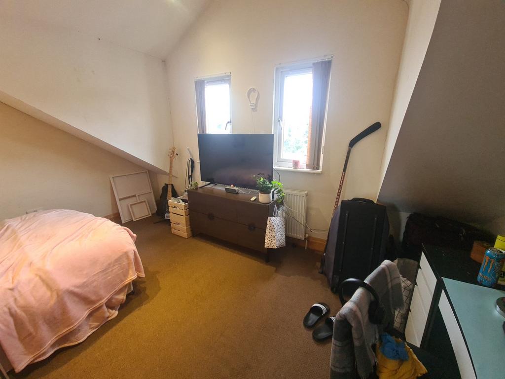 A cozy bedroom featuring a single bed and a sma...