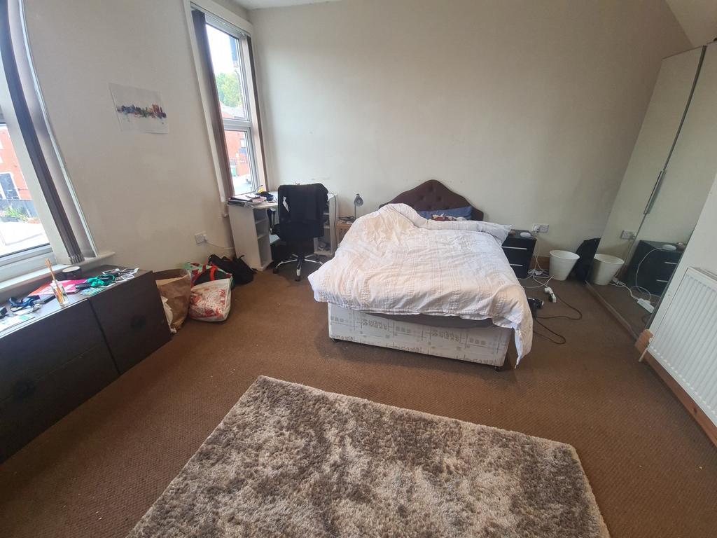 A cozy bedroom featuring a double bed with a pl...