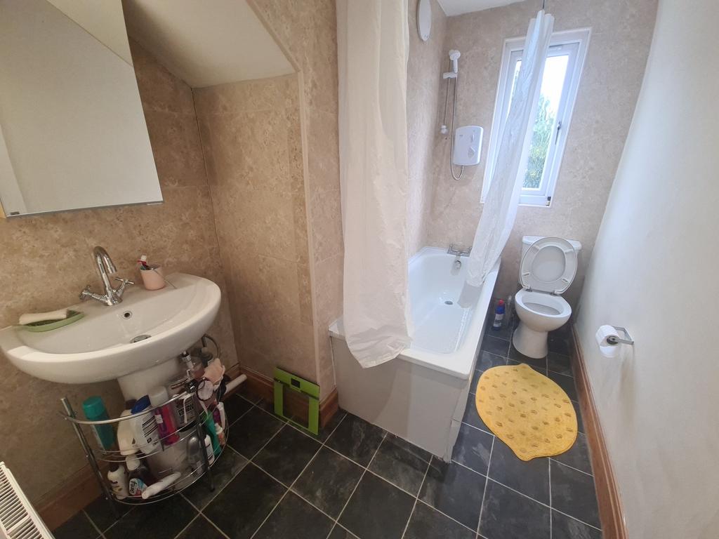 A bright and tidy bathroom featuring a large sh...
