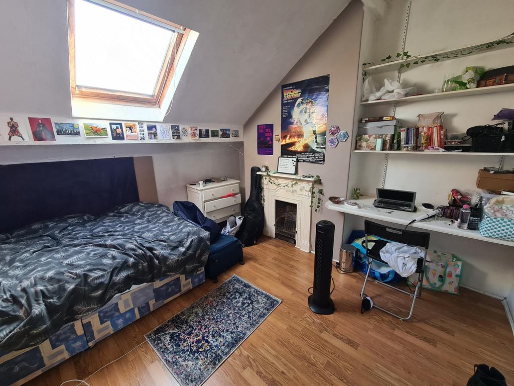 A cozy bedroom featuring a bed, a window provid...