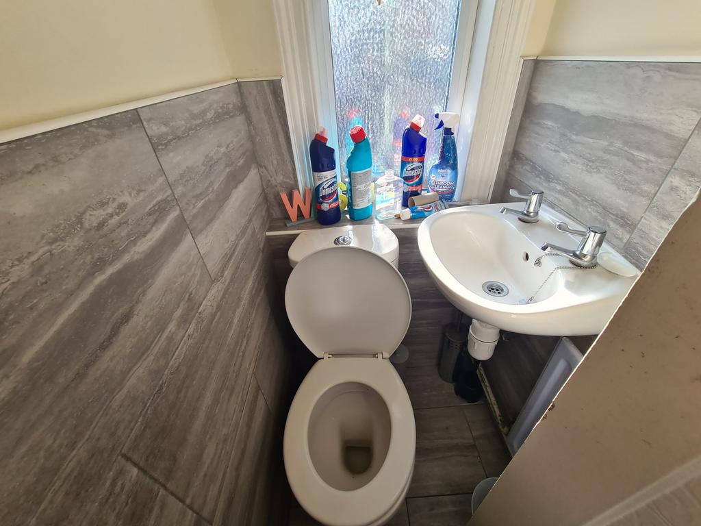 A compact bathroom featuring a toilet and a sma...