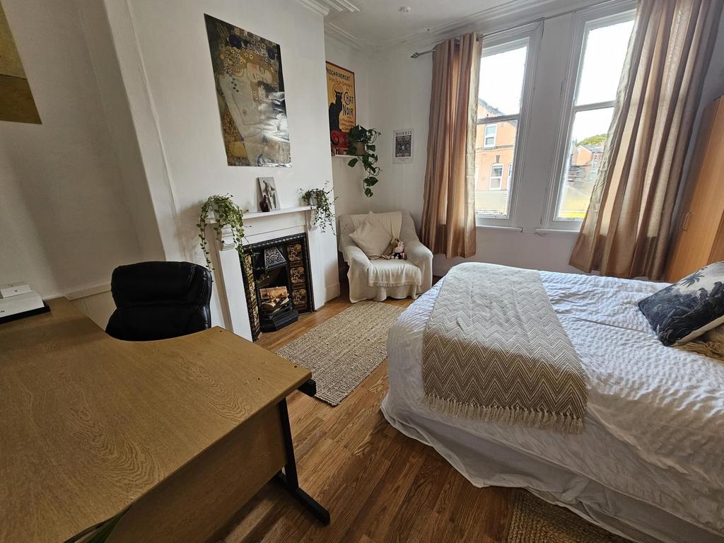 A cozy double bedroom featuring a neatly made b...