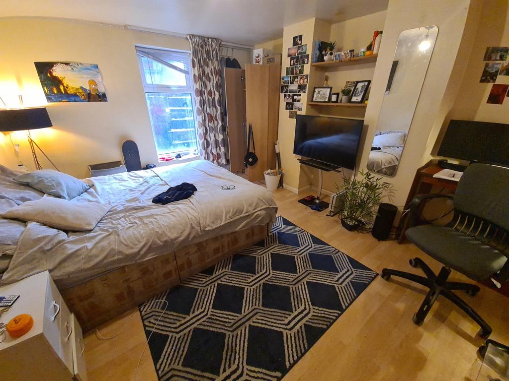 A spacious and well-lit master bedroom featurin...
