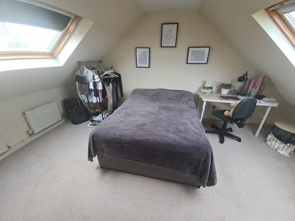 A spacious and well-lit master bedroom featurin...