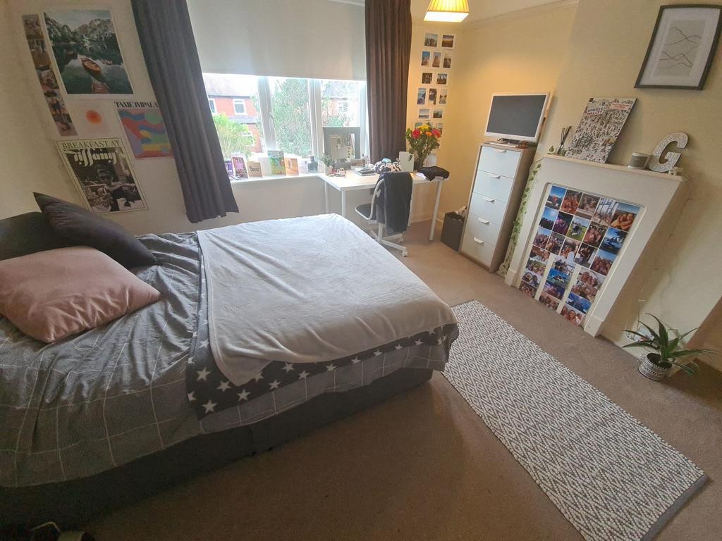 A cozy bedroom featuring a large double bed wit...