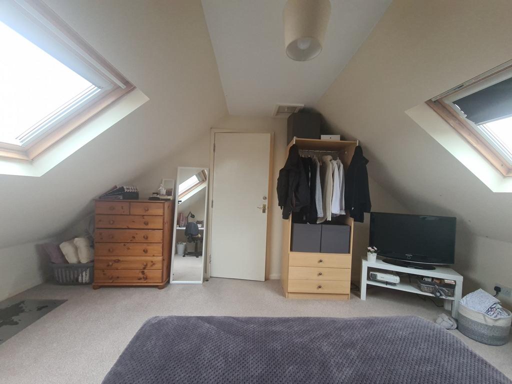 A cozy attic bedroom with skylight windows prov...