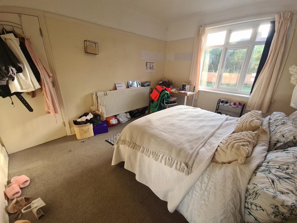 A well-lit bedroom featuring a comfortable doub...
