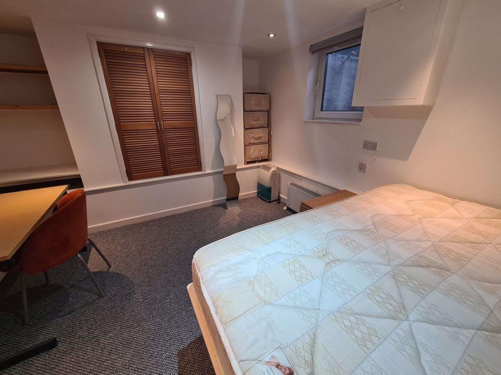 A well-maintained master bedroom featuring a do...