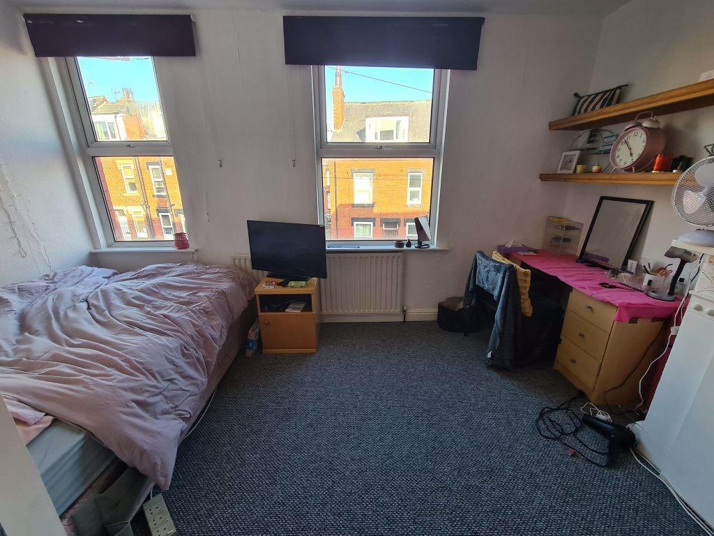 A cozy bedroom featuring a double bed, a small ...