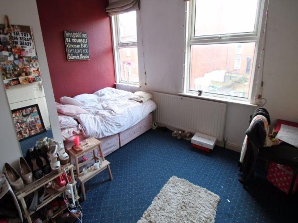 A cozy student bedroom with a single bed, a sma...