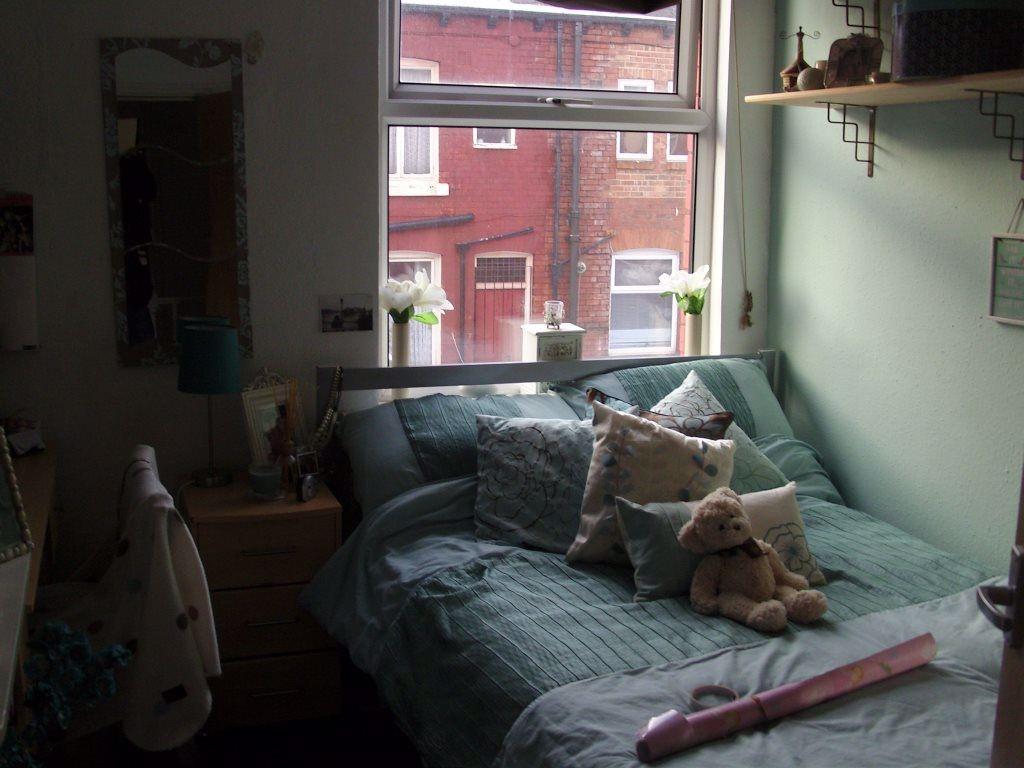 A cozy bedroom featuring a bed with multiple cu...