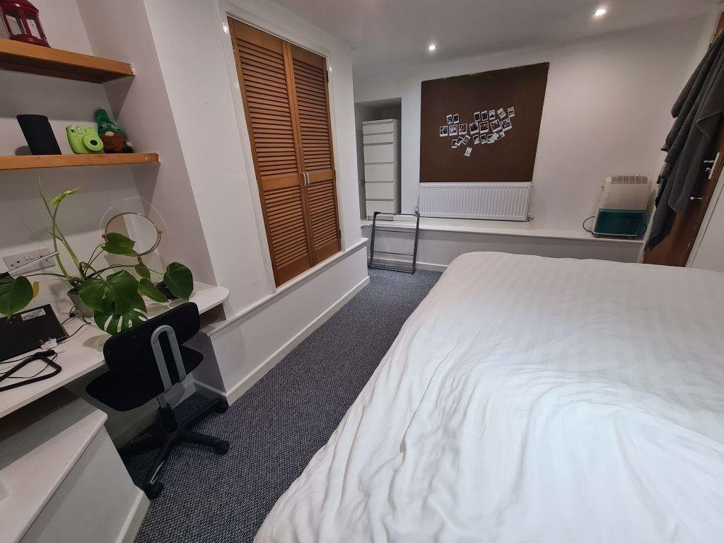 A bright and tidy bedroom featuring a comfortab...