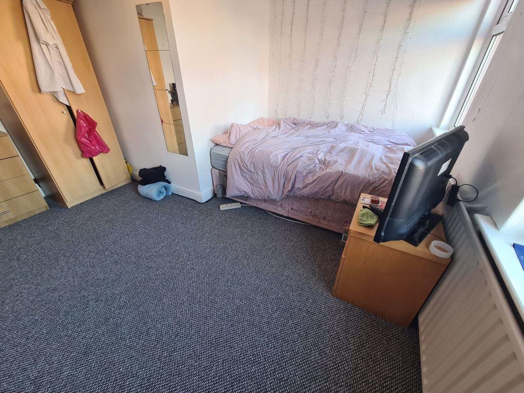 A cozy single bedroom featuring a neatly made b...