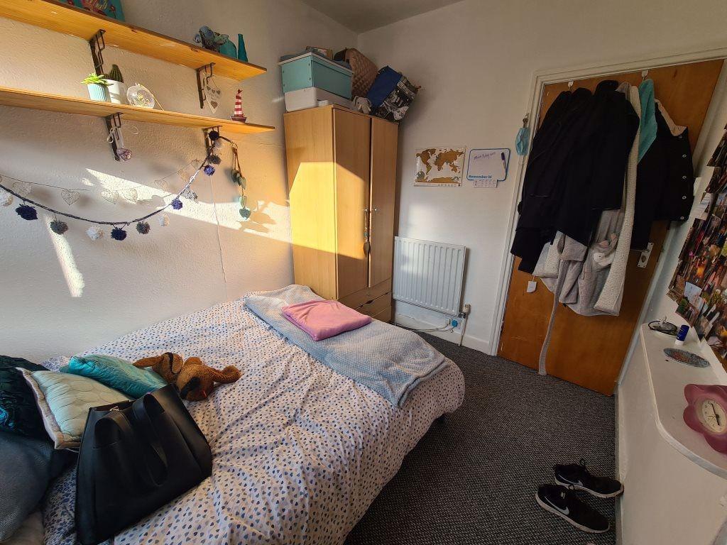 A cozy single bedroom featuring a neatly made b...