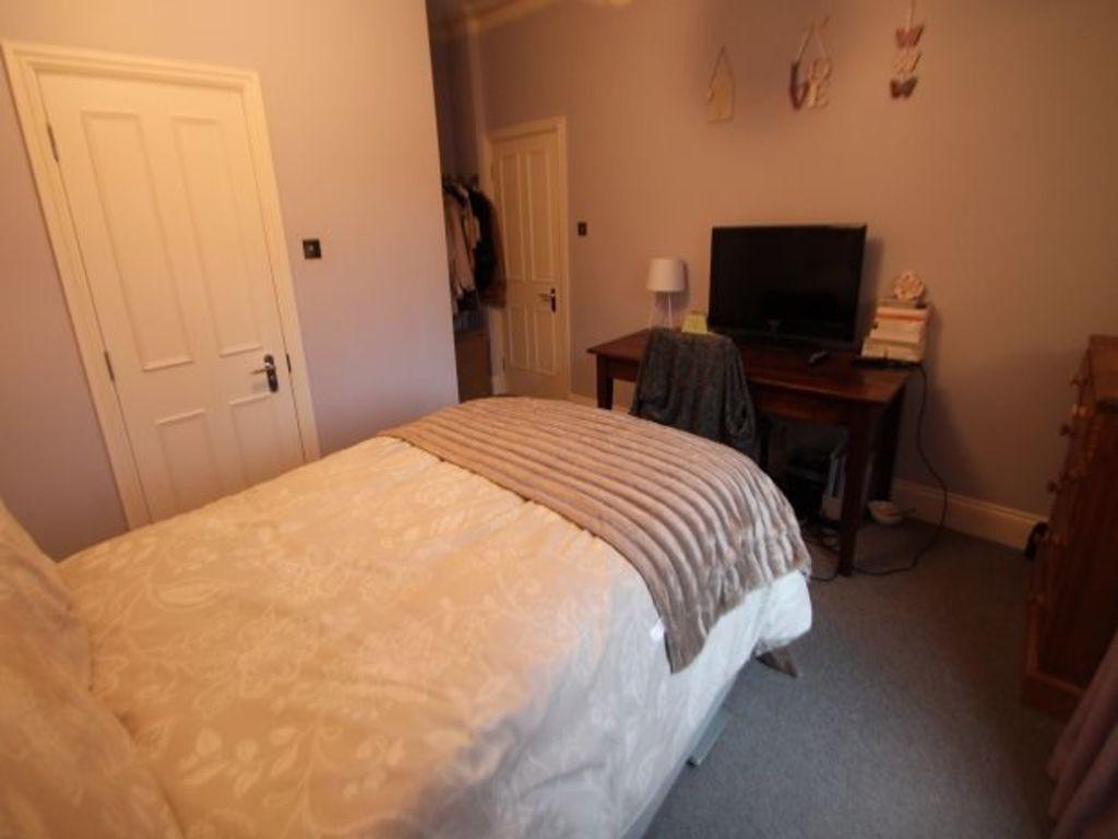 A cozy bedroom featuring a large bed with a com...