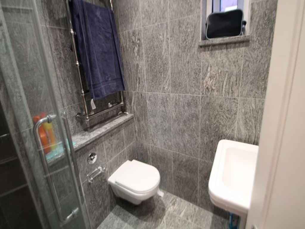 A modern, clean bathroom with a large shower, a...