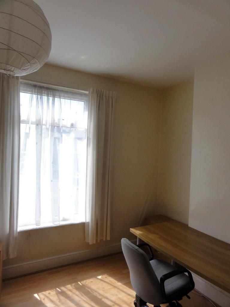 Bright, airy bedroom with a large window allowi...