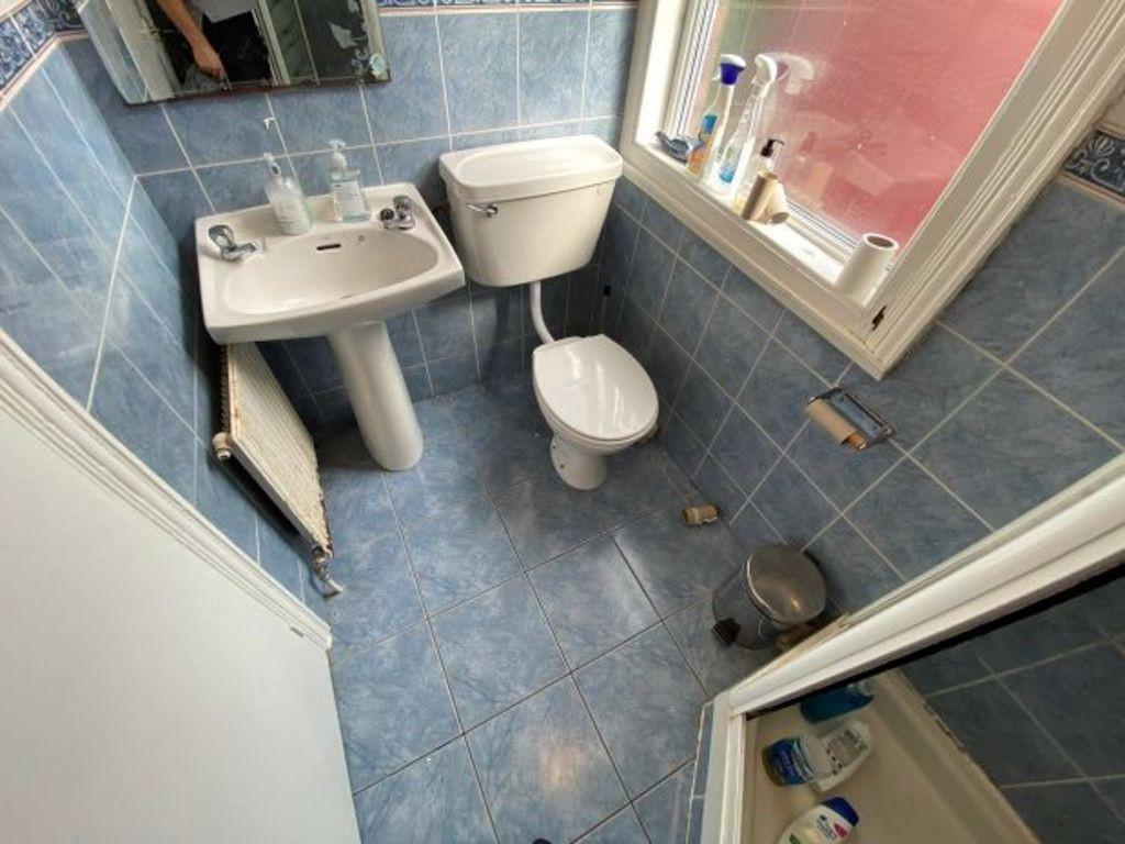 A tidy bathroom featuring a toilet, sink, and w...