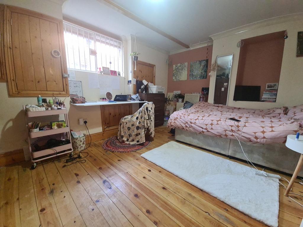 A cozy bedroom with a comfortable bed, wooden f...