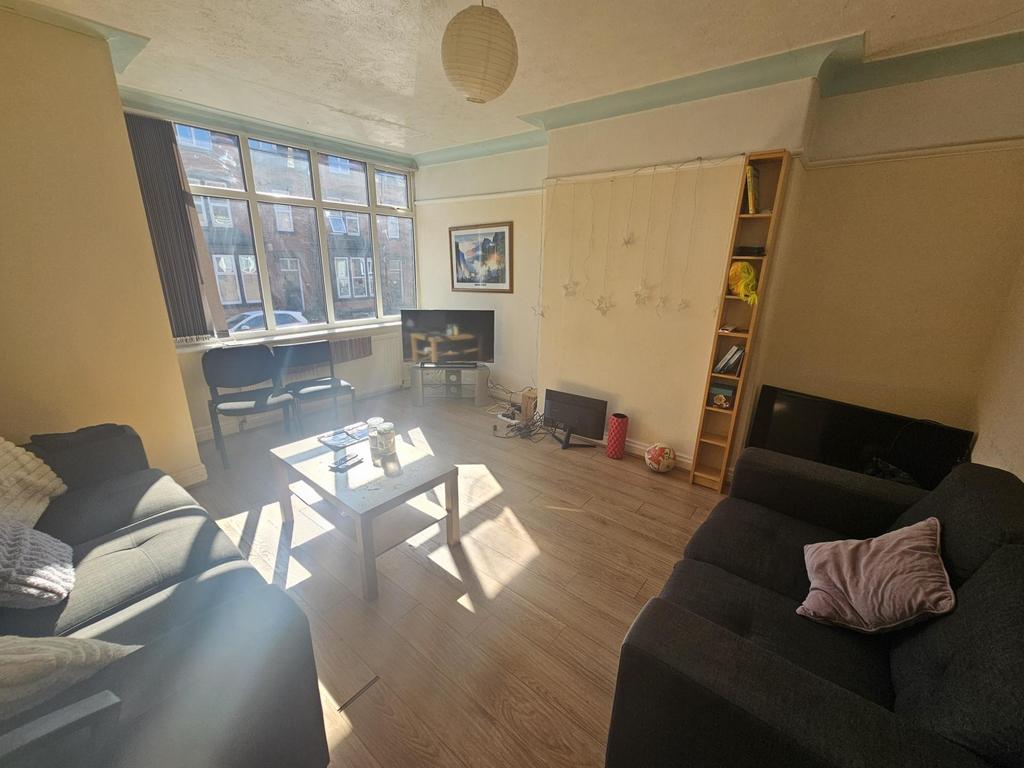 A bright and welcoming living room with ample n...