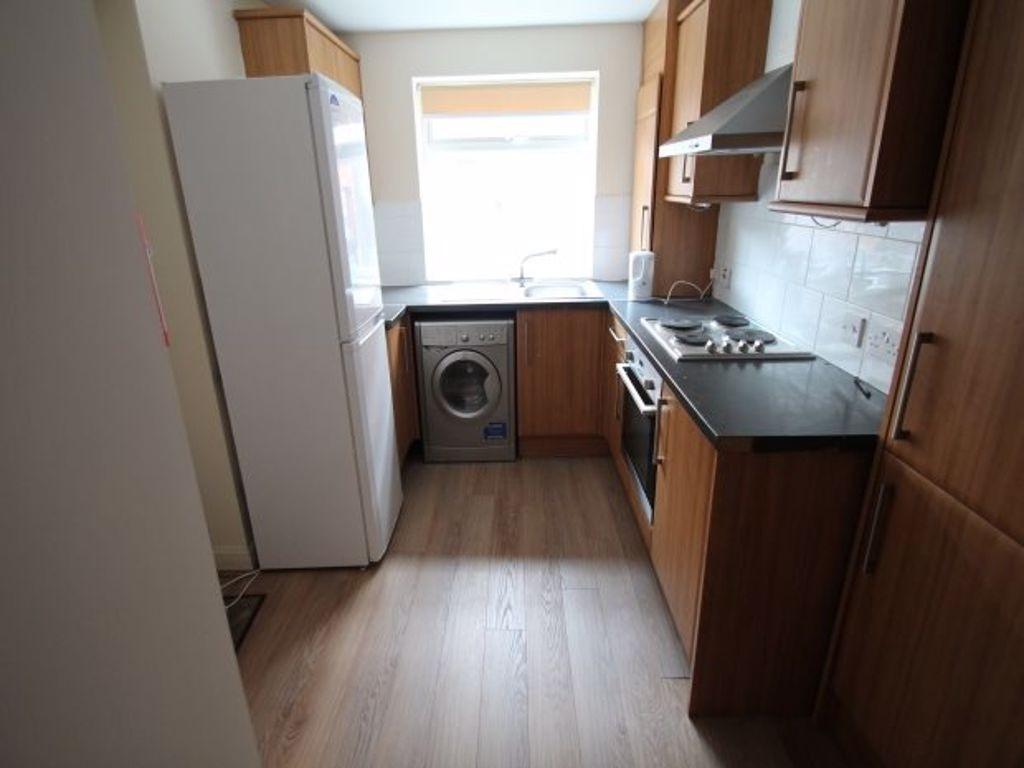 A cozy kitchen with wooden cabinets, a small wi...