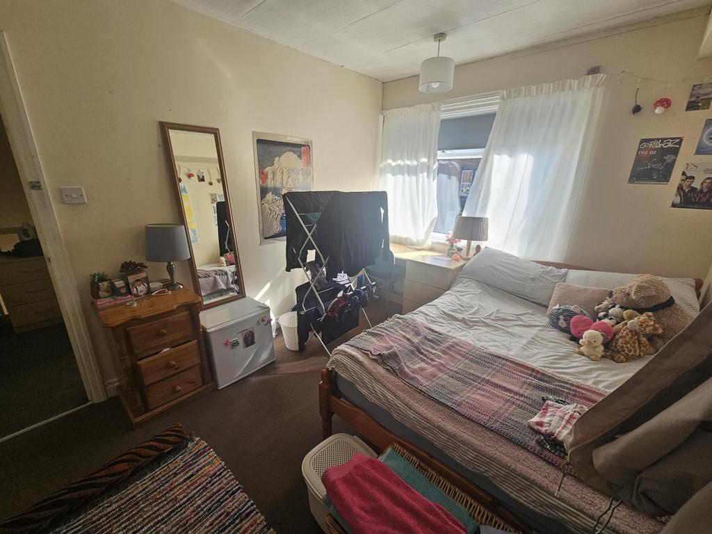 A spacious and well-lit master bedroom with a d...