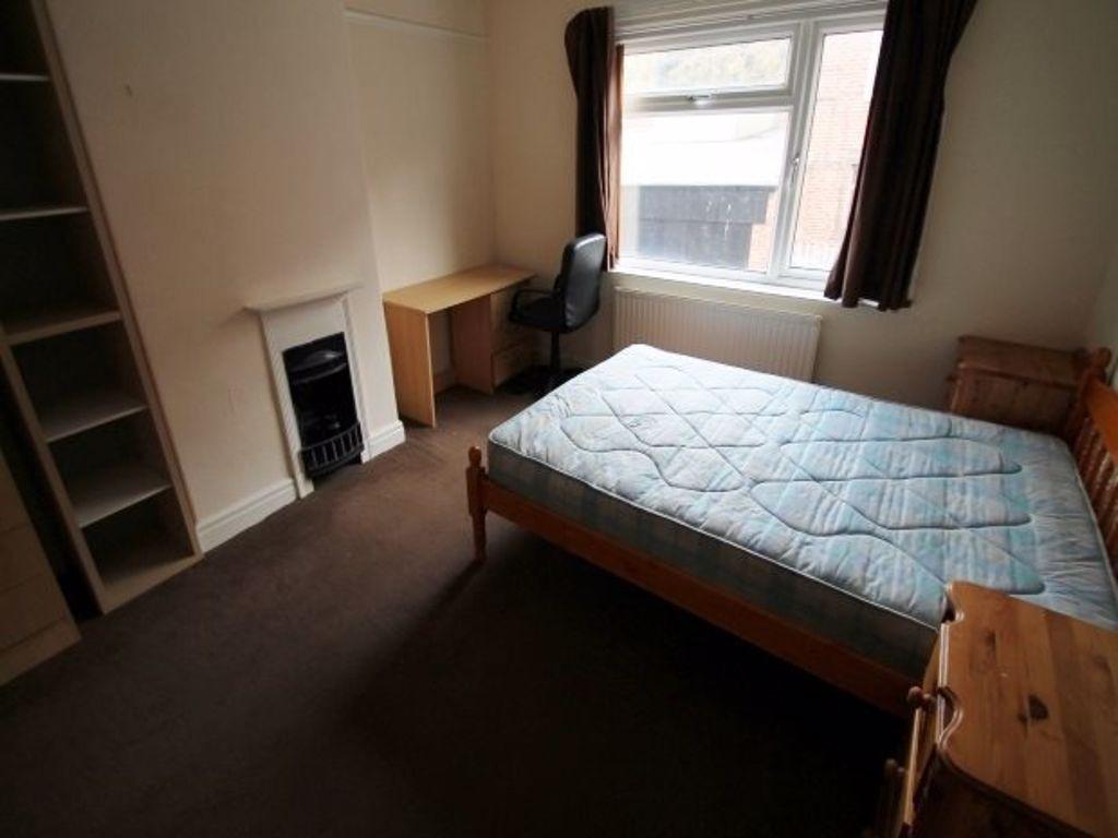 A cozy bedroom featuring a double bed, a window...