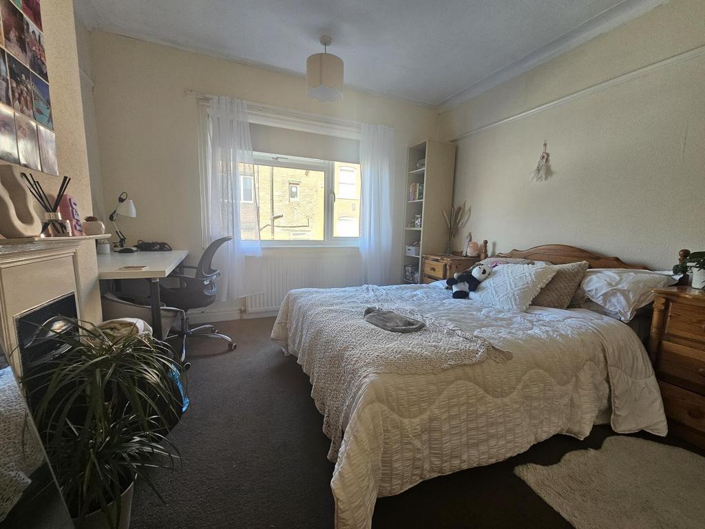 A cozy and well-lit bedroom featuring a double ...
