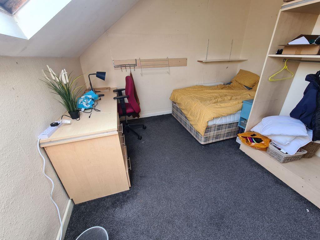 A cozy student bedroom featuring a single bed, ...